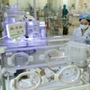Nhân viên y tế chăm sóc cho trẻ sơ sinh. (Ảnh: Dương Ngọc/TTXVN)