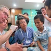 Chuyên gia thăm khám cho trường hợp bệnh nhân bị dị tật hàm mặt. (Ảnh: PV/Vietnam+)