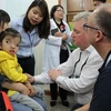 Các chuyên gia của tổ chức Facing The World khám dị tật hàm mặt cho trẻ em. (Ảnh: PV/Vietnam+)