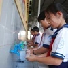 Học sinh rửa tay trước khi vào lớp học. (Ảnh: Huỳnh Phúc Hậu/TTXVN)