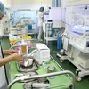 Nhân viên y tế thực hiện việc chăm sóc cho trẻ sơ sinh. (Ảnh: Dương Ngọc/TTXVN)