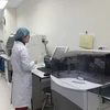 Nhân viên y tế vận hành máy móc tại Phòng xét nghiệm tham chiếu về kháng kháng sinh. (Ảnh: PV/Vietnam+)