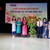 Phó Tổng giám đốc Thông tấn xã Việt Nam Đinh Đăng Quang tặng hoa chúc mừng Ban Nữ công cơ quan TTXVN. (Ảnh: Quang Quyết/TTXVN)