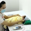 Nhân viên y tế sàng lọc khiếm thính cho sơ sinh tại Trung tâm Sàng lọc-chẩn đoán trước sinh và sơ sinh. (Ảnh: Dương Ngọc/TTXVN)