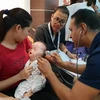 Bác sỹ của tổ chức Facing the world thăm khám cho các em nhỏ dị tật. (Ảnh: TG/Vietnam+)