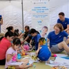 Các tình nguyện viên và các em nhỏ bị dị tật bẩm sinh. (Ảnh: PV/Vietnam+)