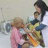 Bộ trưởng Bộ Y tế Nguyễn Thị Kim Tiến trao quà cho bệnh nhân ung thư. (Ảnh: PV/Vietnam+)