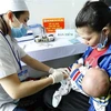 Nhân viên y tế tiêm chủng cho trẻ. (Ảnh:TTXVN/Vietnam+)
