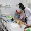 Bác sỹ chăm sóc cho bệnh nhân mắc bệnh tay chân miệng tại tỉnh Bến Tre. (Ảnh: TTXVN)