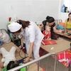 Bác sỹ thăm khám cho bệnh nhân mắc tay chân miệng tại tỉnh Bến Tre. (Ảnh: TTXVN/Vietnam+)