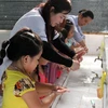 Hướng dẫn học sinh rửa tay bằng xà phòng phòng chống nhiều dịch bệnh. (Ảnh: TTXVN)
