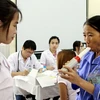Bác sỹ Bệnh viện Bạch mai khám bệnh hen miễn phí cho bệnh nhân. (Ảnh: Dương Ngọc/TTXVN)