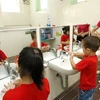 Giáo viên hướng dẫn trẻ rửa tay với xà phòng để phòng chống dịch bệnh. (Ảnh: TTXVN/Vietnam+)