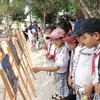 Học sinh tham quan tranh về chủ đề nước sạch. (Ảnh: TTXVN/Vietnam+)