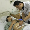 Bác sỹ Bệnh viện E khám lại cho bệnh nhân sau phẫu thuật. (Ảnh: PV/Vietnam+)