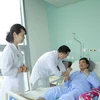 Các bác sỹ Bệnh viện Trung ương Quân đội 108 thăm khám cho bệnh nhân. (Ảnh: PV/Vietnam+)
