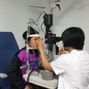 Bác sỹ khám mắt cho bệnh nhân. (Ảnh: PV/Vietnam+)