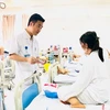 Bác sỹ Vũ Trung Trực, Phó trưởng khoa Phẫu thuật Tạo hình - Thẩm mỹ thăm khám cho bệnh nhân sau 6 ngày phẫu thuật. (Ảnh: PV/Vietnam+)