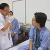 Bác sỹ Nguyễn Thanh Thái kiểm tra sức khoẻ của bệnh nhân sau phẫu thuật. (Ảnh: PV/Vietnam+)