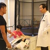 Giáo sư Nguyễn Thanh Liêm trao đổi, kiểm tra sức khỏe cho một bệnh nhân nhi. (Ảnh: T.G/Vietnam+)