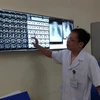 Bác sỹ đọc phim chụp cho bệnh nhân. (Ảnh: PV/Vietnam+)