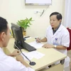 Phó giáo sư Nguyễn Quang khám cho một bệnh nhân. (Ảnh: PV/Vietnam+)