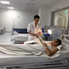 Bác sỹ theo dõi bệnh nhân sau phẫu thuật. (Ảnh: PV/Vietnam+)