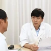 Phó giáo sư Nguyễn Xuân Hùng khám cho bệnh nhân. (Ảnh: PV/Vietnam+)