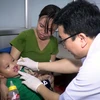 Bác sỹ Bệnh viện Hữu nghị Việt Nam Cu Ba khám cho trẻ bị sứt môi. (Ảnh: PV/Vietnam+)