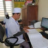 Nhân viên y tế kiểm tra sổ sách tại Trạm y tế xã Kim Chính, huyện Kim Sơn, Ninh Bình. (Ảnh: PV/Vietnam+)