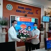 Nữ bệnh nhân và người thân tặng hoa cảm ơn các y bác sỹ đã cứu sống. (Ảnh: PV/Vietnam+)