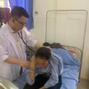Bác sỹ Trần Hữu Cảnh khám cho một bệnh nhân tại Bệnh viện đa khoa huyện Quỳnh Nhai. (Ảnh: PV/Vietnam+)