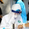 Nhân viên Y tế lấy mẫu máu test nhanh cho các công dân trở về từ Đà Nẵng. (Ảnh: Thành Đạt/TTXVN)