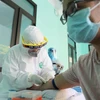 Nhân viên y tế lấy mẫu máu để xét nghiệm nhanh cho người dân tại Trạm Y tế phường Dịch Vọng, quận Cầu Giấy. (Ảnh: Thanh Tùng/TTXVN)