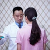 Thạc sỹ Nguyễn Đình Minh kiểm tra các chỉ số cho nữ bệnh nhân. (Ảnh: PV/Vietnam+)