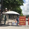 Người dân trong khu vực phong tỏa trên phố Ngô Quyền (Hải Dương) nhận thực phẩm tiếp tế tại hàng rào cách ly ngày 16/8. Ảnh: Mạnh Minh- TTXVN