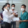 Phó Bí thư Thường trực Nguyễn Văn Quảng trao quà cảm ơn đến các y, bác sỹ đã hỗ trợ Đà Nẵng phòng, chống dịch COVID-19. (Ảnh: Văn Dũng/TTXVN)