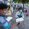 Phát tờ khai thông tin y tế cho người dân Phú Yên đến lấy mẫu xét nghiệm COVID-19. (Ảnh: Trần Lê Lâm/TTXVN)