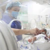 Nhân viên y tế chăm sóc cho trẻ sơ sinh. (Ảnh: PV/Vietnam+)