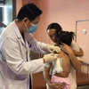 Bác sỹ kiểm tra sức khoẻ cho bé gái sau phẫu thuật. (Ảnh: PV/Vietnam+)