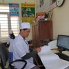 Bác sỹ theo dõi sổ khám bệnh tại một trạm y tế xã ở tỉnh Ninh Bình. (Ảnh: T.G/Vietnam+)
