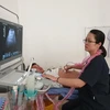 Bác sỹ Đàm Thanh Huyền thuộc dự án bác sỹ trẻ tình nguyện siêu âm cho một bệnh nhân tại Bệnh viện đa khoa huyện Quỳnh Nhai, Sơn La. (Ảnh: PV/Vietnam+)