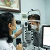 Khám, kiểm tra mắt cho bệnh nhân. (Ảnh: PV/Vietnam+)
