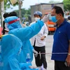 Kiểm tra thân nhiệt của người dân để phòng chống dịch COVID-19. (Ảnh: TTXVN/Vietnam+)