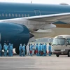 Các cơ quan chức năng phối hợp với Hãng hàng không quốc gia Việt nam thực hiện chuyến bay đặc biệt đón công dân Việt Nam từ Guinea Xích đạo về nước. (Ảnh: TTXVN) 