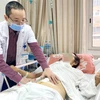 Bác sỹ khám cho bệnh nhân sau phẫu thuật. (Ảnh: PV/Vietnam+)