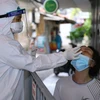 Lực lượng y tế quận Hai Bà Trưng lấy mẫu xét nghiệm SARS-CoV-2 cho những người có nguy cơ cao. (Ảnh: Hoàng Hiếu/TTXVN)