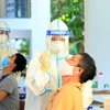 Nhân viên y tế lấy mẫu xét nghiệm SARS-CoV-2 cho người dân. (Ảnh: Tuấn Anh/TTXVN)