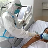 Nhân viên y tế chăm sóc cho bệnh nhân mắc COVID-19. (Ảnh: PV/Vietnam+)