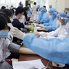 Khám sàng lọc cho học sinh trước khi tiêm vaccine. (Ảnh: TTXVN/vietnam+)